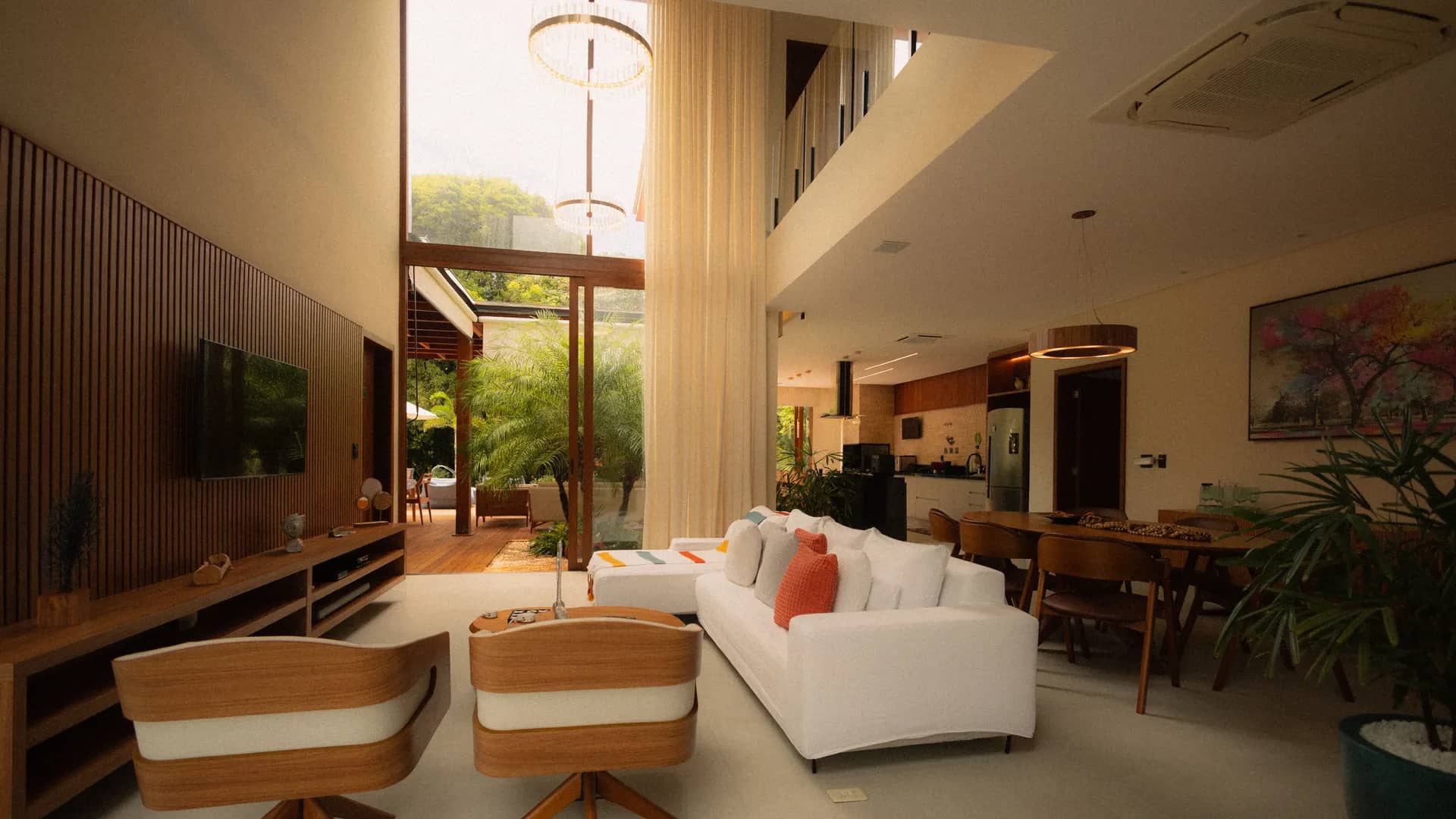 Double-height living room with timber joinery, a dining area and floor-to-ceiling glazing