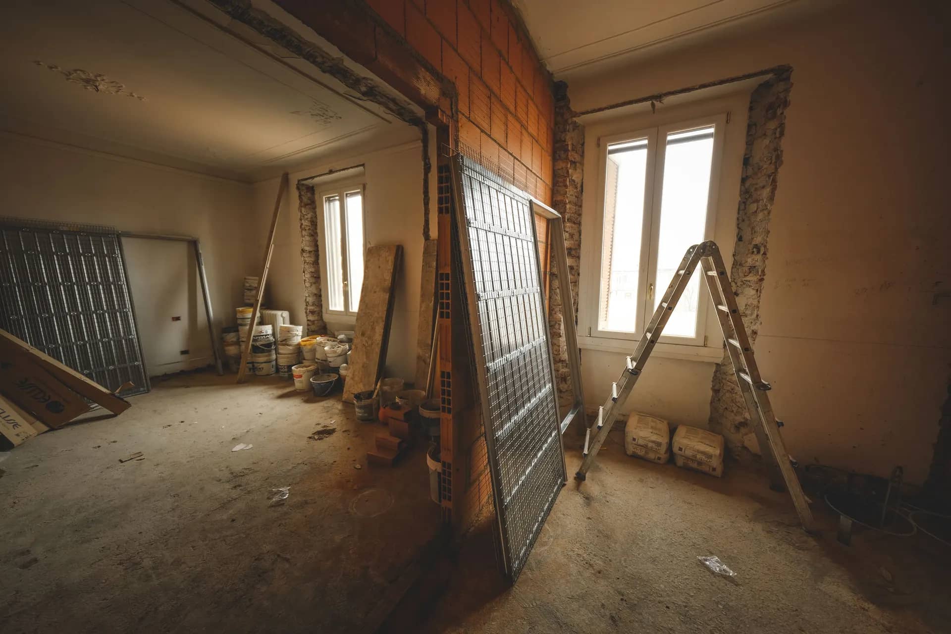 Room stripped back during a renovation, with door frames removed and materials stacked